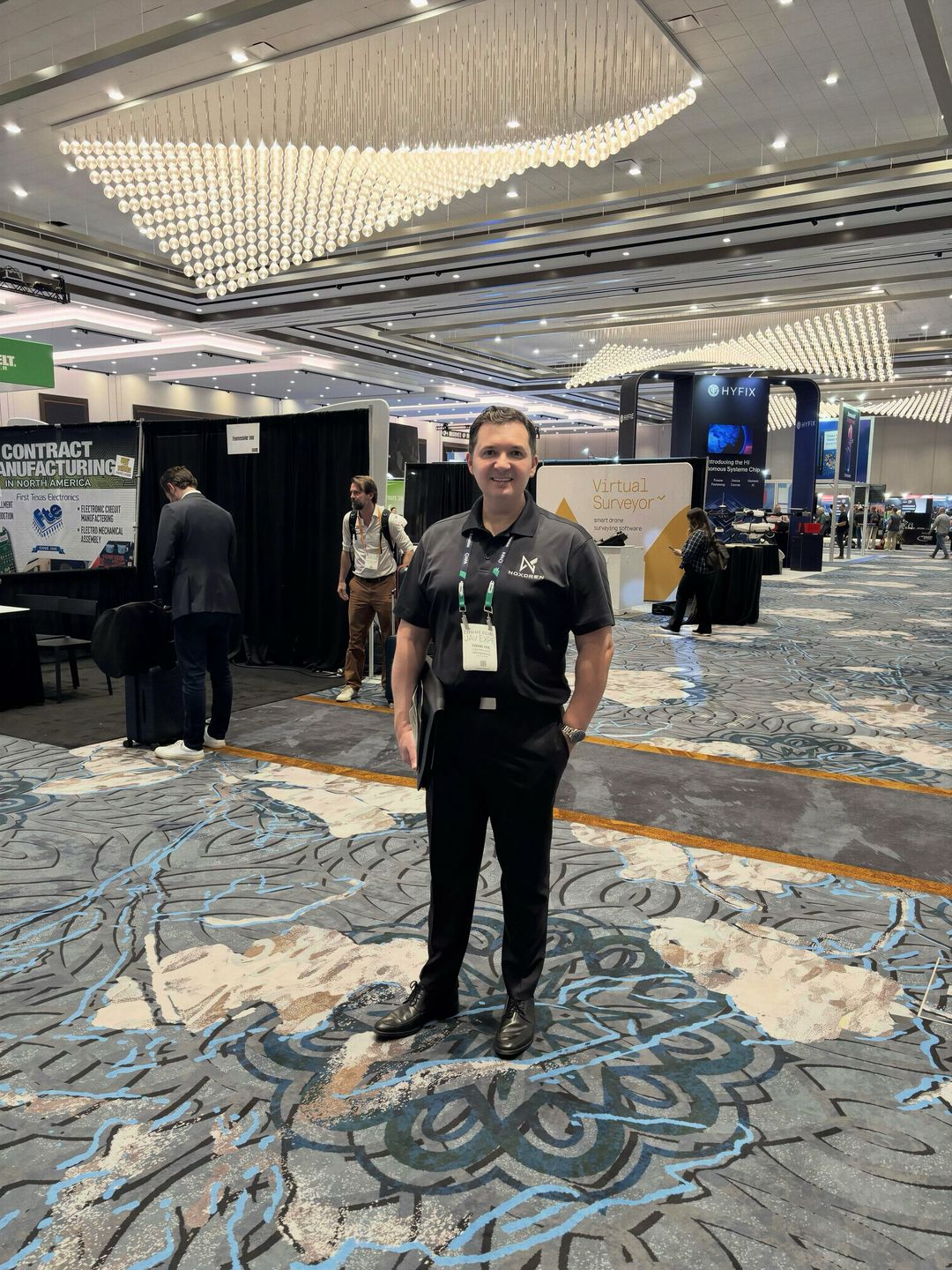Ermin Vila wearing a black Noxdren polo on the Commercial UAV Expo exhibition floor.